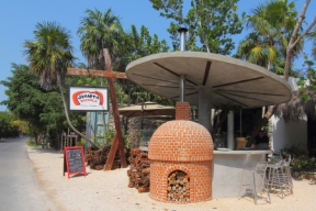 a beach side stand with brick oven made pizza and bread