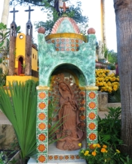 headstone with a religious theme and statue of the virgin de guadalupe